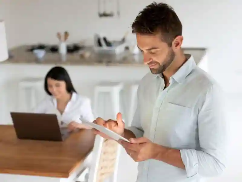 Man controlling his smart home using a digital tablet.